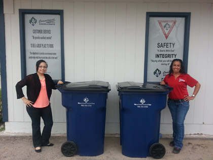 Photo of Waste Connections RGV customer service reps, Angel and Lety, standing by residential trash carts.